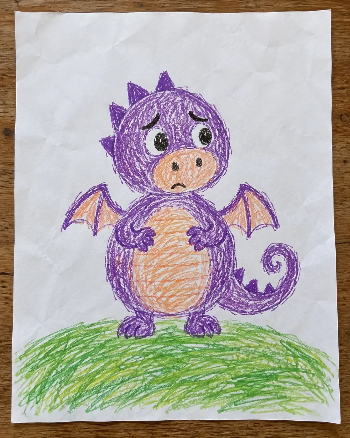 A child's crayon drawing of a small round violet dragon with worried eyebrows